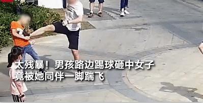 小男孩踢足球踢到小女孩,小孩在小区门口踢足球被一脚踹飞
