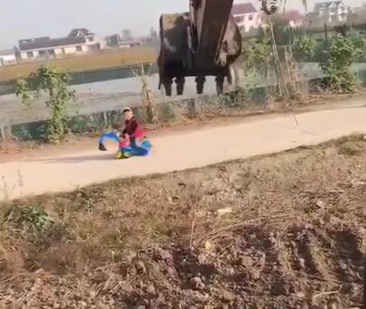 小男孩开大型挖掘机干活,男孩开着挖掘机