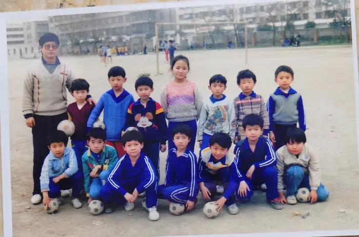 小孩儿在篮球场上踢足球,孩子体育场踢足球