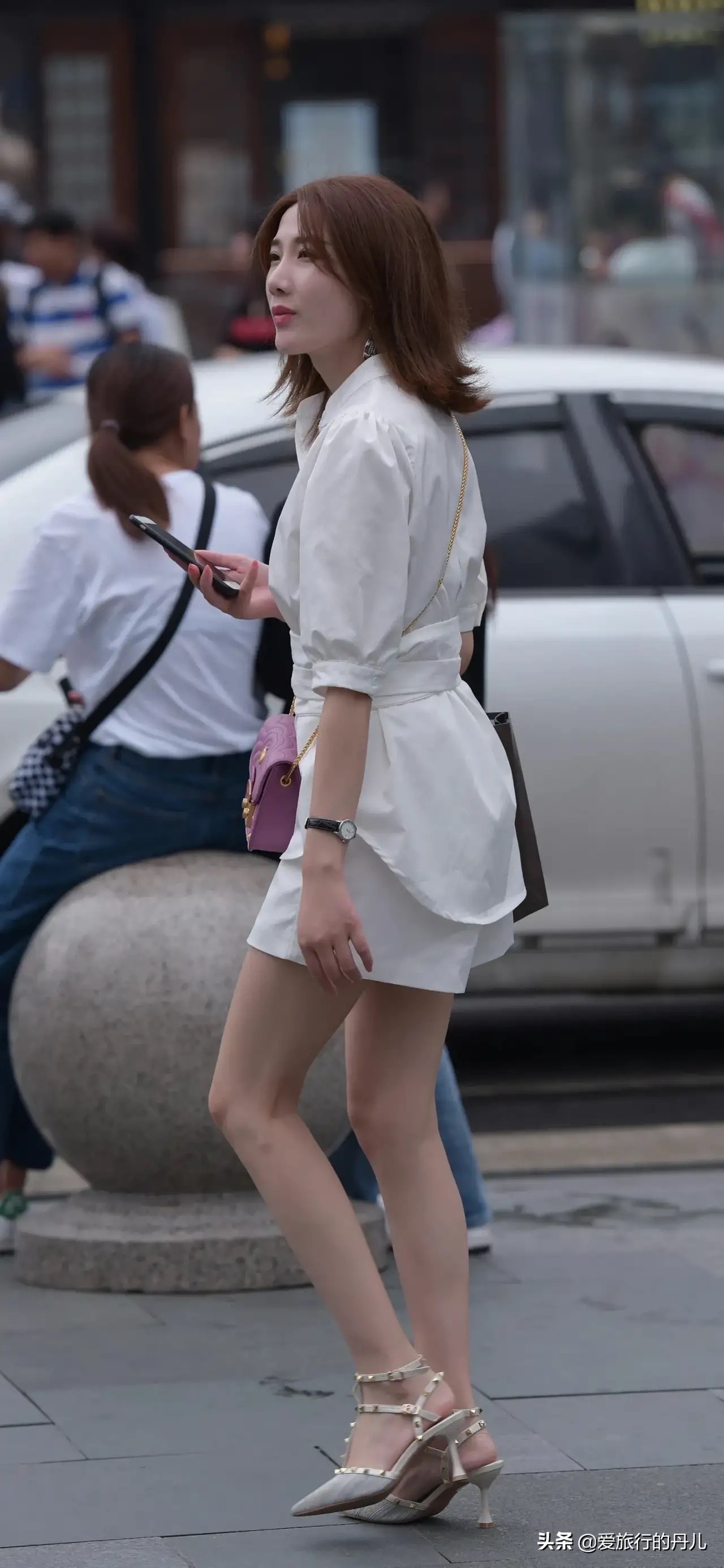 小姐姐身穿白色长款衬衫搭配白色休闲短裤，清新又时尚